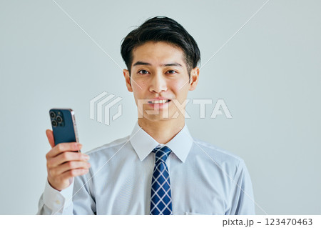 スマホを持つワイシャツ姿の若い男性 123470463