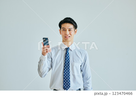スマホを持つワイシャツ姿の若い男性 123470466
