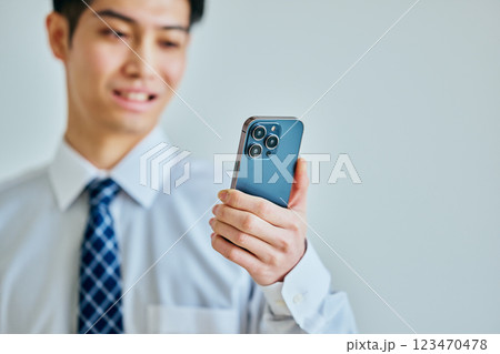 スマホを持つワイシャツ姿の若い男性 スマホを持つワイシャツ姿の若い男性 123470478