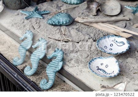 Shop window with ceramics on the sand. Ceramics on a marine theme, plates, shells and sea turtles. Shop window with ceramics on the sand. Ceramics on a marine theme, plates, shells and sea turtles. 123470522