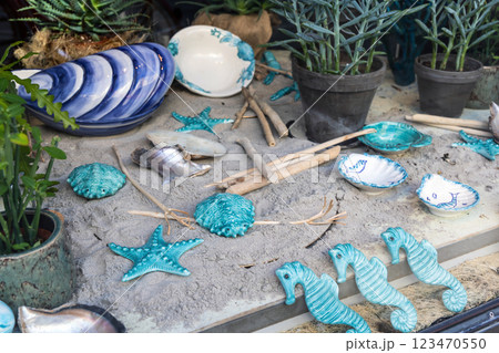 Shop window with ceramics on the sand. Ceramics on a marine theme, plates, shells and sea turtles. Shop window with ceramics on the sand. Ceramics on a marine theme, plates, shells and sea turtles. 123470550