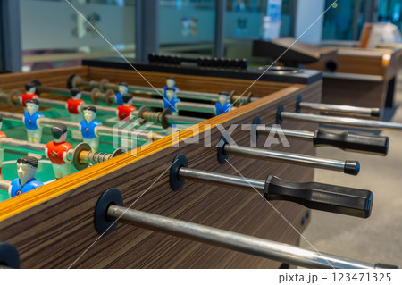 Retro table soccer with wooden miniature figurines of players on metal bars Retro table soccer with wooden miniature figurines of players on metal bars 123471325