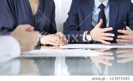 Business partners or lawyers are reviewing contract terms during a meeting, negotiating and making decisions together. Business people concept, close up view Business partners or lawyers are reviewing contract terms during a meeting, negotiating and making decisions together. Business people concept, close up view 123471485