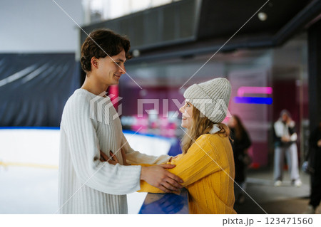 Young couple enjoying ice skating together at an indoor rink 123471560
