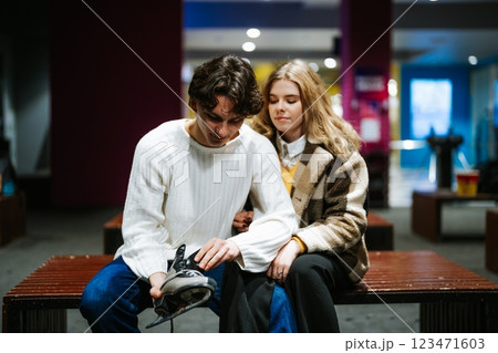 Young couple enjoys ice skating together while getting ready at rink 123471603