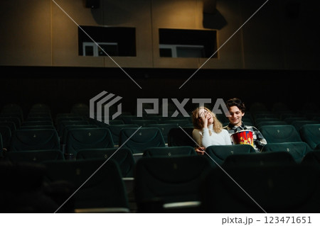 Couple enjoying a movie together in an almost empty theater at night Couple enjoying a movie together in an almost empty theater at night 123471651