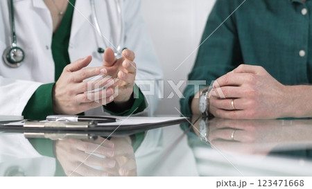 Doctor using hand gestures to explain diagnosis to patient during medical consultation, providing support and guidance for healthcare decisions Doctor using hand gestures to explain diagnosis to patient during medical consultation, providing support and guidance for healthcare decisions 123471668
