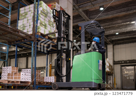 冷蔵倉庫でフォークリフトに乗る男性 冷蔵倉庫でフォークリフトに乗る男性 123471779