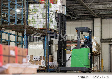 冷蔵倉庫でフォークリフトに乗る男性 冷蔵倉庫でフォークリフトに乗る男性 123471780