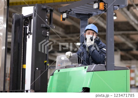 冷蔵倉庫でフォークリフトに乗る男性 冷蔵倉庫でフォークリフトに乗る男性 123471785