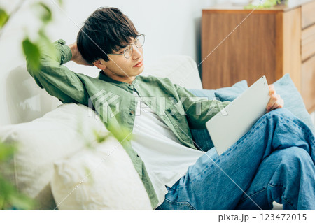 リビングでくつろぐ男性　タブレット 123472015