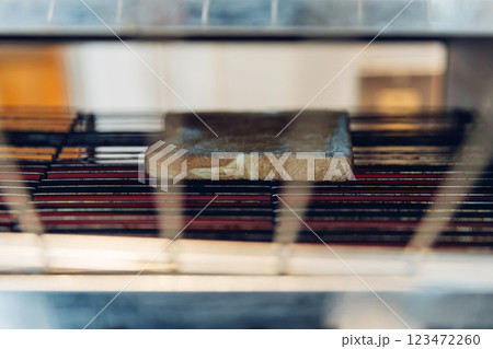 Bread from electrical Conveyor Toaster Oven toasting is operated  123472260