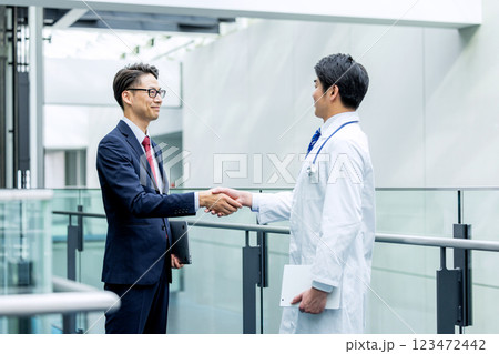 握手をする医師とビジネスマン 123472442