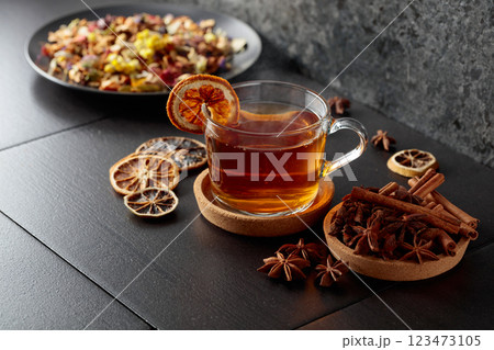 Cup of herbal tea with ingredients and slices of dried orange slices. 123473105