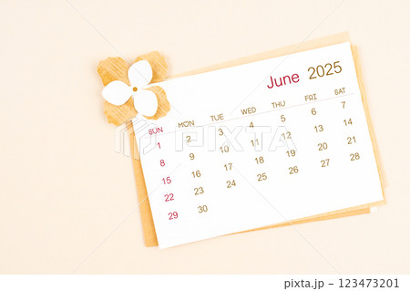 June 2025 calendar with origami flower paper on beige color. 123473201