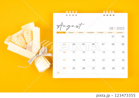 2025 August desk calendar and Yellow bouquet on yellow background. 2025 August desk calendar and Yellow bouquet on yellow background. 123473355
