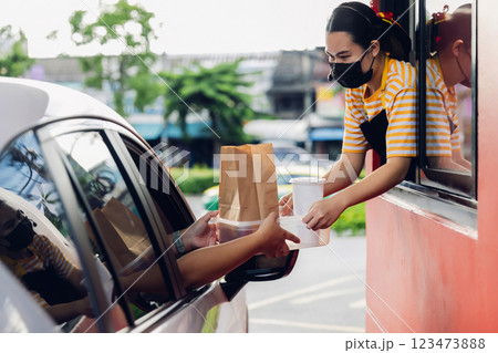Hand Man in car receiving coffee in drive thru fast food restaurant. 123473888