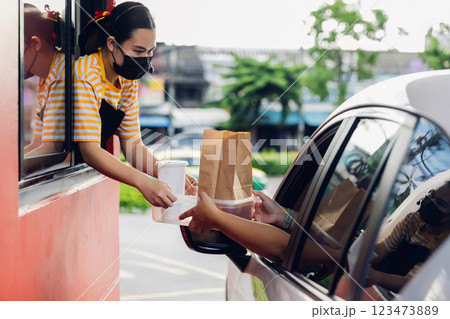 Hand Man in car receiving coffee in drive thru fast food restaurant. 123473889
