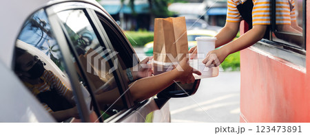 Hand Man in car receiving coffee in drive thru fast food restaurant. 123473891