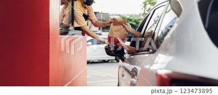 Hand Man in car receiving coffee in drive thru fast food restaurant. 123473895