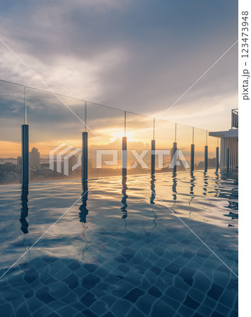 Stunning sunset view from a pool overlooking a city skyline with skyscrapers and mountains at dusk Stunning sunset view from a pool overlooking a city skyline with skyscrapers and mountains at dusk 123473948