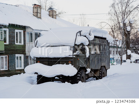 Snow-covered vehicle parked on a quiet street in winter Snow-covered vehicle parked on a quiet street in winter 123474386