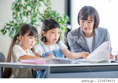 勉強をする小学生と家庭教師 123474413