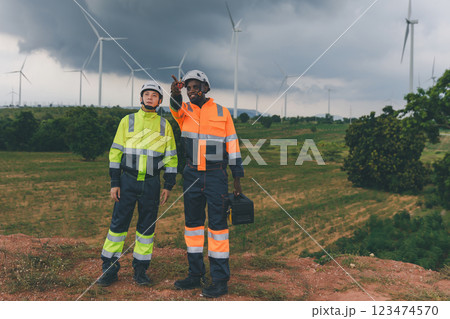 Professional Man Maintenance engineers working in wind turbine farm at sunset. 123474570