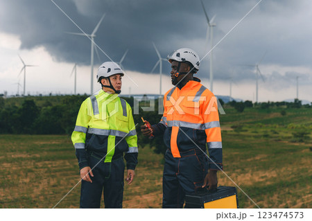 Professional Man Maintenance engineers working in wind turbine farm at sunset. 123474573