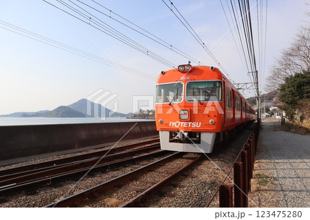 興居島の伊予小富士を背景に走る伊予鉄道高浜線の電車 123475280