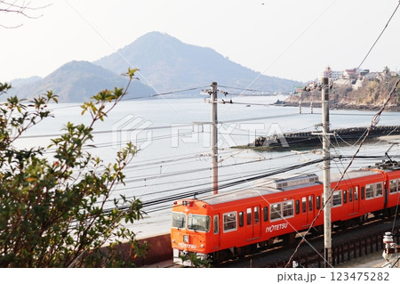 興居島の伊予小富士を背景に走る伊予鉄道高浜線の電車 興居島の伊予小富士を背景に走る伊予鉄道高浜線の電車 123475282