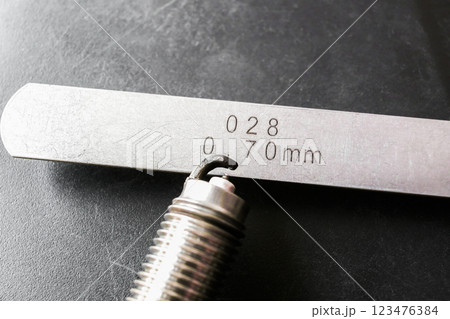 Close up of spark plug and feeler gauge or thickness gauge to adjust the gap of spark plug 123476384