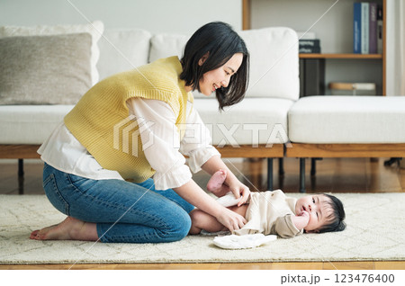 赤ちゃんのおむつを取り替えるママ 123476400