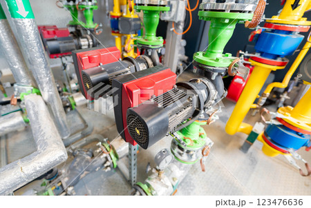 Industrial circulation pumps with electric motors connected to a complex piping system Industrial circulation pumps with electric motors connected to a complex piping system 123476636