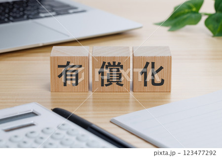 テーブルの上に有償化と書かれたブロック 123477292