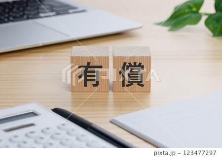 テーブルの上に有償と書かれたブロック 123477297