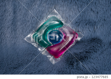 Washing gel capsule on material textile background Washing gel capsule on material textile background 123477685