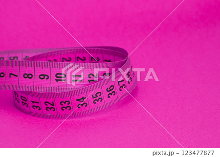 Pink tape measure diet concept on background with copyspace 123477877