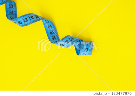 Spiral tape measure colorful background with copyspace Spiral tape measure colorful background with copyspace 123477970