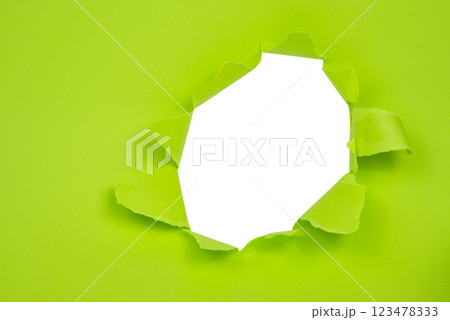 Hole in paper green background torn damaged for design 123478333