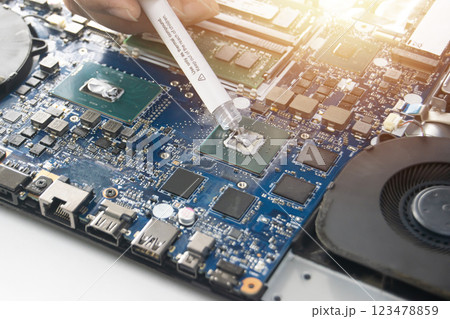 Technician is adding thermal silicone to the CPU. 123478859