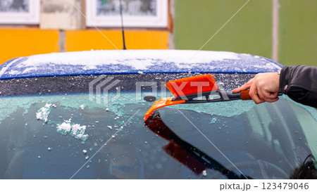 A person is cleaning the cars windshield with a brush 123479046