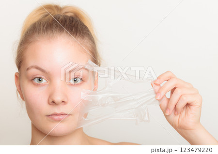 girl removing facial peel off mask 123479220