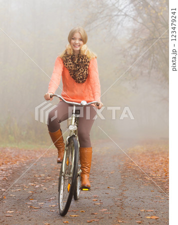 Happy active woman riding bike in autumn park. 123479241