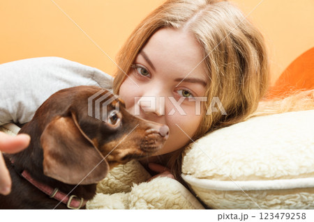 Woman with dog waking up in bed after sleeping. 123479258