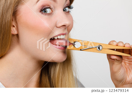 Blonde woman having tongue in clothespin Blonde woman having tongue in clothespin 123479314