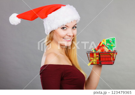 Santa woman holding shopping cart with christmas gifts Santa woman holding shopping cart with christmas gifts 123479365