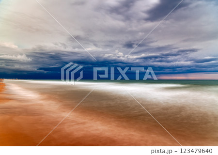The blurred movement of waves creates a serene and contemplative atmosphere on the sandy beach. The blurred movement of waves creates a serene and contemplative atmosphere on the sandy beach. 123479640