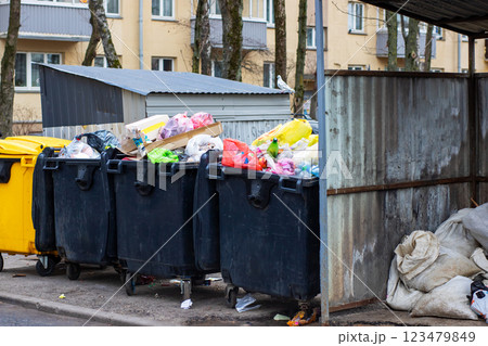 A series of garbage cans are neatly lined up along the side of the road A series of garbage cans are neatly lined up along the side of the road 123479849