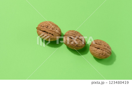 Walnut fruits on a green background, close up 123480419
